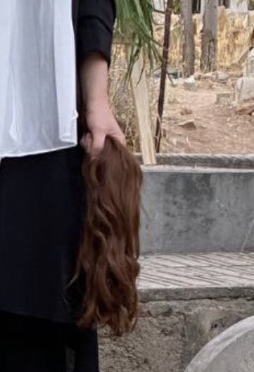 زنی-که-موهایش-را-کوتاه-کرده-و-در-دستش-گرفته-جنبش-زن-زندگی-آزادی